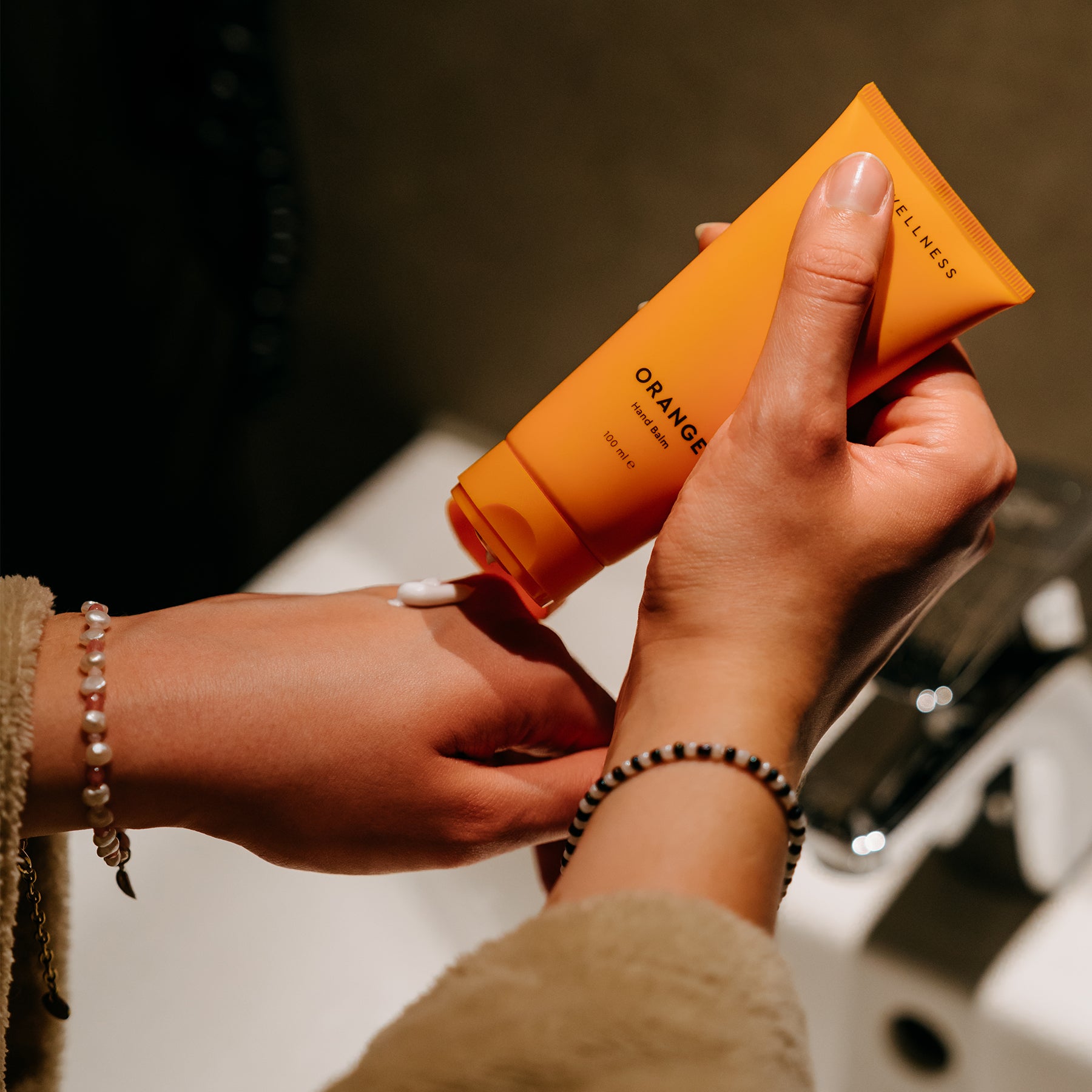 Eine Person hält den MyWellness Hand Balm Orange – pflegende Handcreme für geschmeidig weiche Hände mit Orange-Rosmarin-Duft.