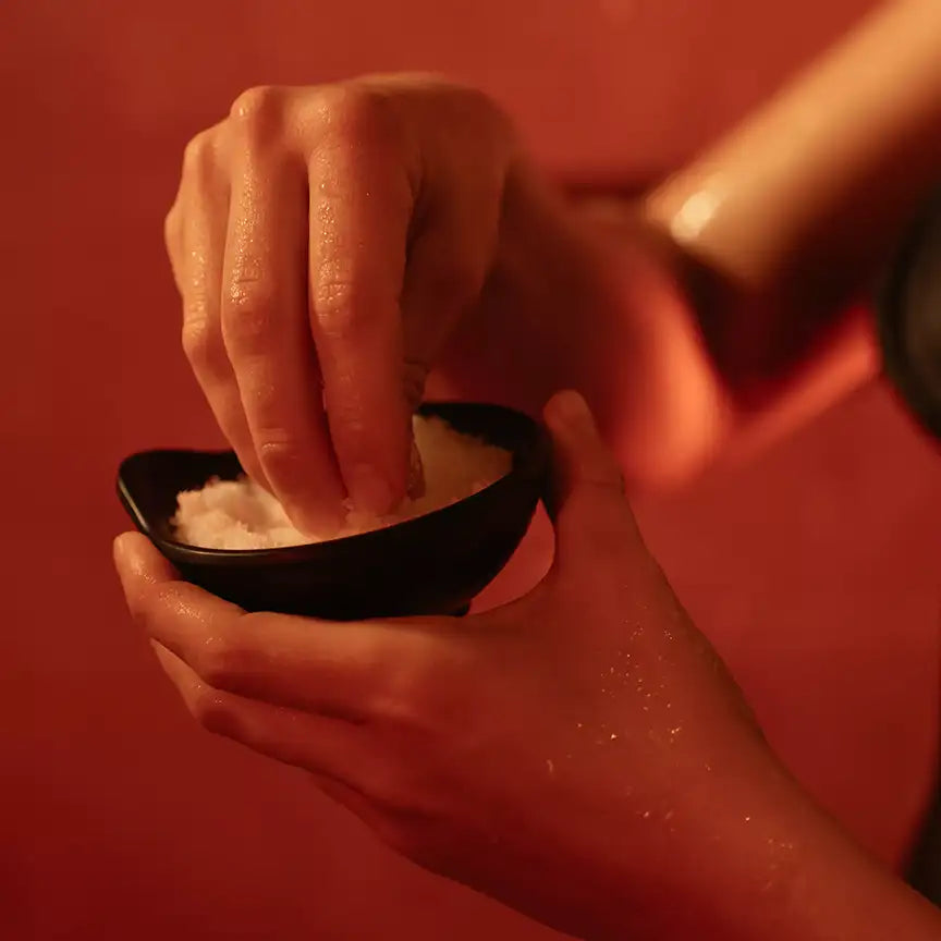 Person entnimmt MyWellness Body Scrub Lemon aus Schale – pflegendes Zitronen-Körperpeeling mit natürlichen Inhaltsstoffen