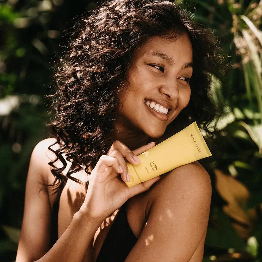 Frau hält MyWellness Hand Balm Lemon – natürliche Handpflege mit Zitronenduft für weiche, gepflegte Haut