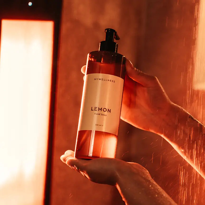 MyWellness Hand Soap Lemon in der Hand gehalten – luxuriöse Handseife mit natürlichem Zitronenaroma im warmen Licht