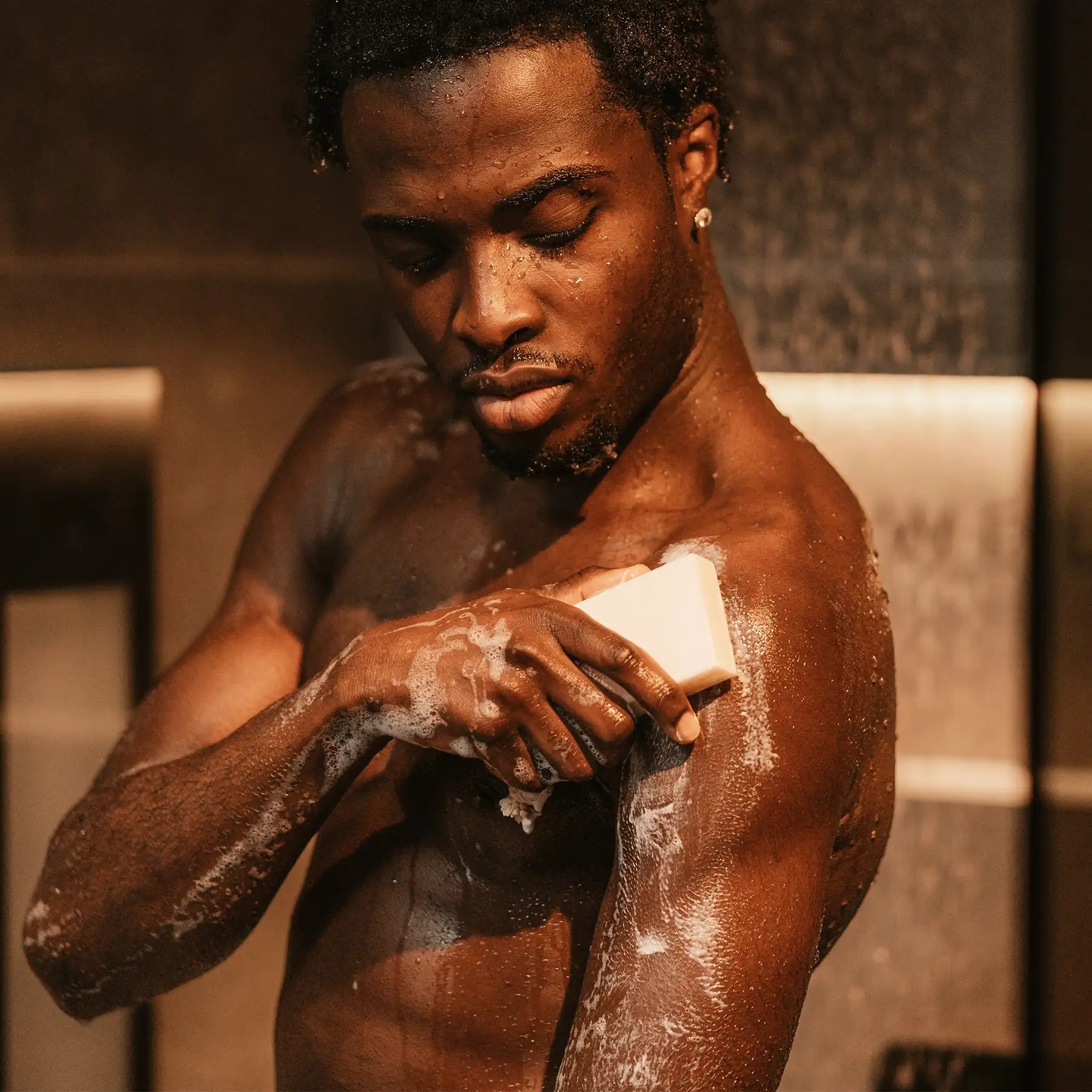 Person nutzt MyWellness Shower Bar Lemon unter der Dusche – feste Duschseife mit Zitronenduft für sanfte Reinigung