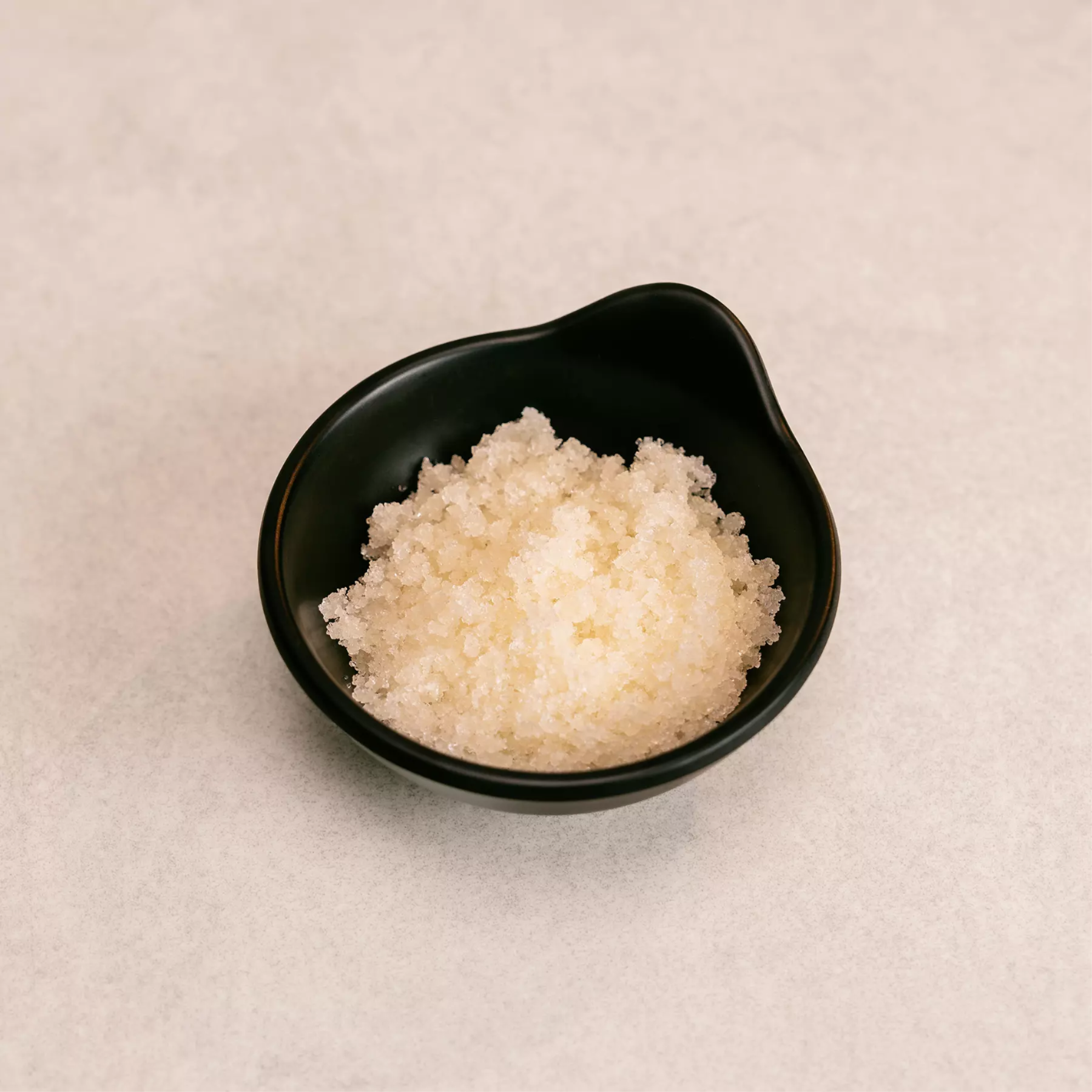 Schwarze Schale gefüllt mit Meersalz-Peeling Body Scrub Orange von MyWellness