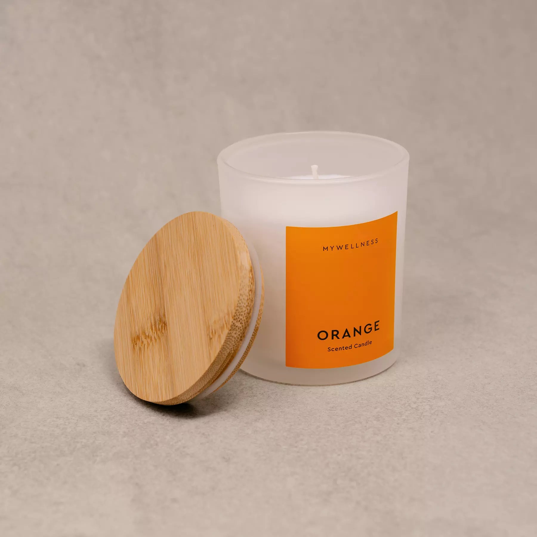 Orange Duftkerze mit geöffnetem Holzdeckel in Seitenansicht