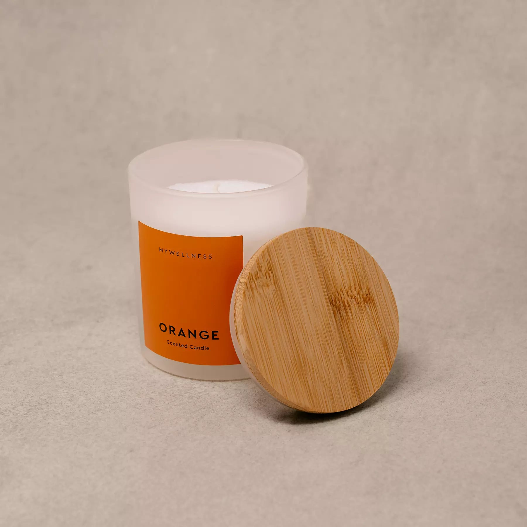 Orange Duftkerze mit Holzdeckel im minimalistischen Produktfoto