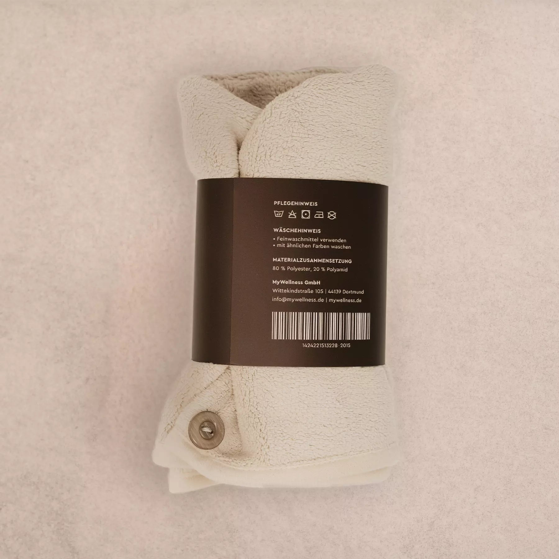 Gefalteter MyWellness Haarturban mit Pflegehinweisen und Knopfverschluss – hochwertig verarbeitet und schnelltrocknend