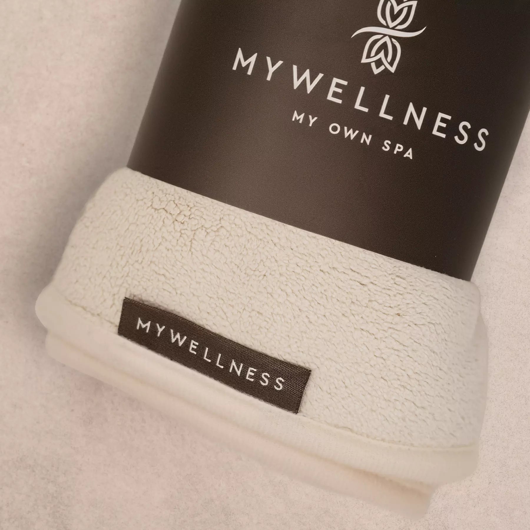 Verpackter MyWellness Haarturban mit schwarzer Logo-Banderole – harmonisches Design passend zu Bademantel und Saunatuch