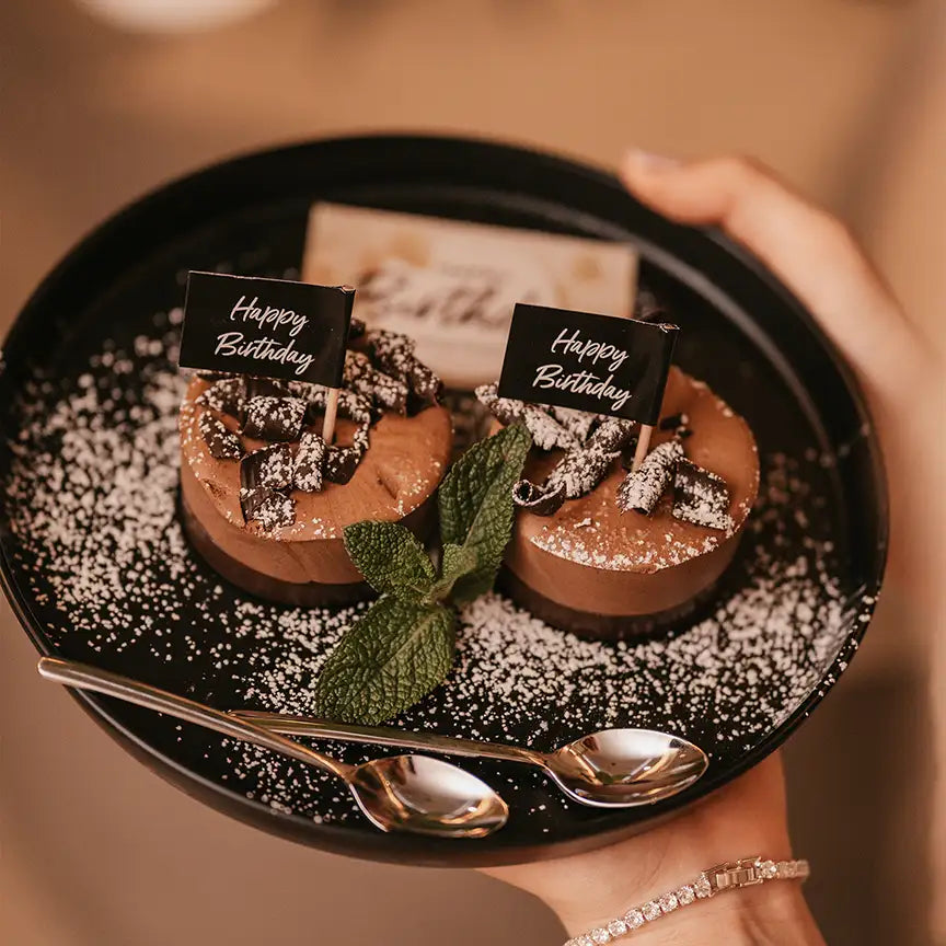 Desserts auf MyWellness Tellern serviert – stilvolle Präsentation von Gebäck und Süßspeisen auf mattschwarzem Geschirr