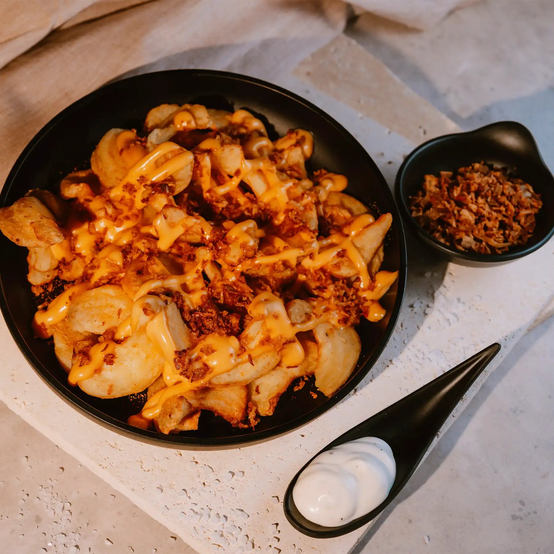 Mattschwarzer MyWellness Melamin-Teller mit Loaded Fries – stilvolle Servieridee für Spa oder Outdoor